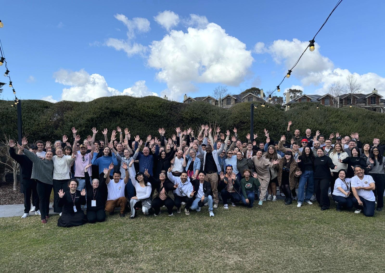 a group of people at engage sqaured posing for a photo on the grass